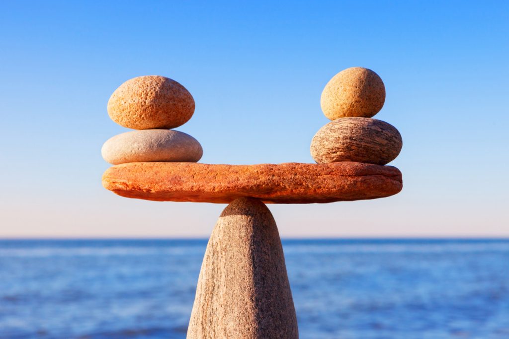 Balance/scale made out of stones equal on each side with an ocean background